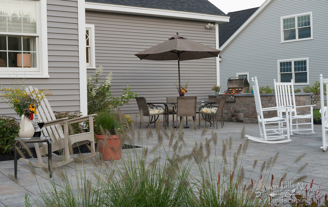 Paver patio with dining set, grill station and ornamental grasses