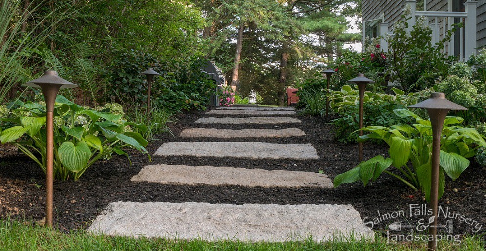 Stone garden path lined with hosta beds and low-voltage landscape lighting
